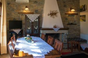 a dining room with a table and a fireplace at Anna maria in Agios Dimitrios