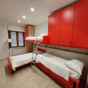 two bunk beds in a room with red cabinets at ViaProperzio8 in Foligno