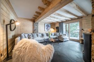 sala de estar con sofá y mesa en Les Balcons de Pralong Courchevel 1850 - by EMERALD STAY, en Courchevel