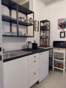 una cocina con armarios blancos y fregadero en Guiscarda Turismo, en Bari