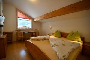 een slaapkamer met een bed, een tafel en een raam bij Residence Dilitz in Resia