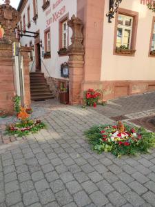 a group of flowers on a sidewalk in front of a building at Hotel & Restaurant Zum Riesen in Walldürn