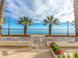 einen Strand mit Palmen und dem Meer in der Unterkunft Apartment Mar Menor by Interhome in Los Alcázares