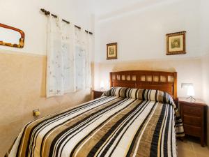 Schlafzimmer mit einem Bett mit gestreifter Decke in der Unterkunft Apartment Mar Menor by Interhome in Los Alcázares