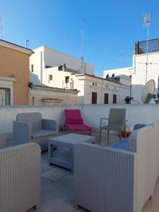 eine Terrasse mit Stühlen und Tischen auf dem Dach in der Unterkunft Guiscarda Turismo in Bari