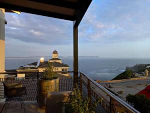 a balcony with a view of a building and the ocean at The Waterfront Penthouse in Hermanus