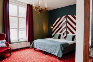 um quarto com uma cama, uma cadeira e um lustre em Landgoed Halsaf em Babberich