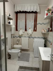 La salle de bains est pourvue de toilettes et d'une fenêtre avec des serviettes. dans l'établissement Marino, à Sassuolo
