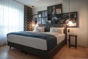 a bedroom with a large bed with a blue blanket at Art Hotel Superior in Aachen