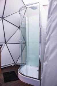 una ducha de cristal en una tienda de campaña en la cúpula en Domo, en Bello