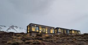a house on a hill with mountains in the background at Summit Trip Winter Lodge in Los Molles