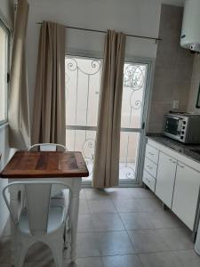 een keuken met een tafel en stoelen en een raam bij Junin dptos 1 in San Fernando del Valle de Catamarca