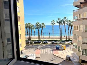 a view from a window of a parking lot with palm trees at Frente a la playa Malagueta Arenal, 10 personas in Málaga