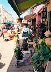 a group of people sitting at an outdoor cafe with potted plants at L' Ecume de Mer in Châtelaillon-Plage