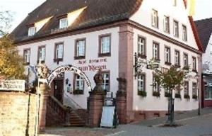 a white building with an arch in front of it at Hotel & Restaurant Zum Riesen in Walldürn