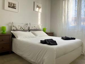 um quarto com uma cama branca com duas toalhas pretas em Deliziosa Casetta a Bologna em Bolonha