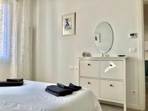 Habitación blanca con tocador blanco y espejo en Deliziosa Casetta a Bologna, en Bolonia