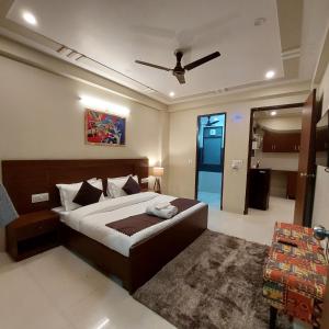 The Lodgers 2 BHK Serviced Apartment infront of Artemis Hospital Gurgaon في جورجاون: غرفة نوم بسرير ومروحة سقف