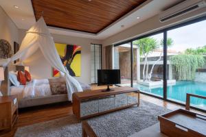 a bedroom with a bed and a swimming pool at Berry Amour Romantic Villas in Seminyak
