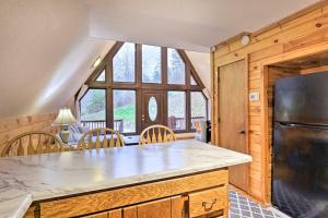 a kitchen with a refrigerator and a table with chairs at Cozy Yatesville Lake Cabin Rental in Louisa! in Louisa