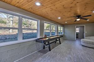 a game room with a ping pong table and windows at Fayetteville Vacation Rental - 2 Mi to Dtwn! in Fayetteville