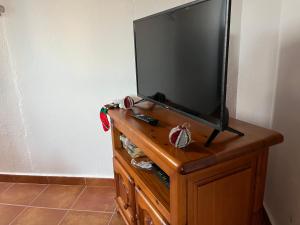uma televisão de ecrã plano em cima de uma cómoda de madeira em Casa de campo Yuco em Tinajo
