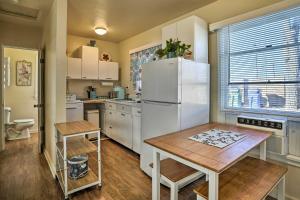 uma cozinha com um frigorífico branco e uma mesa em Vibrant Prescott Cottage with Private Backyard! em Prescott