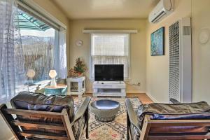 a living room with two chairs and a flat screen tv at Vibrant Prescott Cottage with Private Backyard! in Prescott