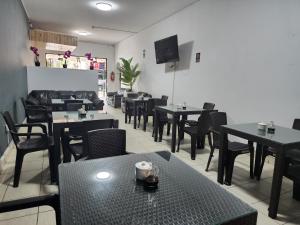 un restaurante con mesas, sillas y TV en Hotel Villa del Sol, en Piura