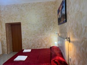 a bedroom with a red bed with two towels on it at Monlight Guest House in Rome