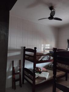 a room with two bunk beds and a ceiling fan at Casa Mongaguá Plataforma in Mongaguá