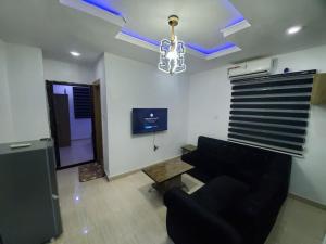 een woonkamer met een bank en een tafel bij DINERO DIAMOND - ONE BED APARTMENT in Lagos