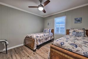a bedroom with two beds and a ceiling fan at Charming Gulfport Home about 2 Mi to Marina in Gulfport