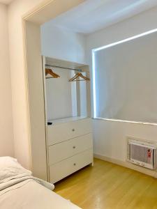 1 dormitorio con cama, tocador y espejo en Apartamento Encantador Leme - Prédio na Orla en Río de Janeiro