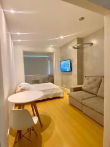 Apartamento Encantador Leme - Prédio na Orla في ريو دي جانيرو: غرفة نوم بسرير وطاولة واريكة