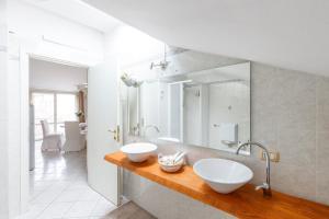 a bathroom with two white sinks on a wooden counter at Elly's Home [Parcheggio Privato] in Ravenna