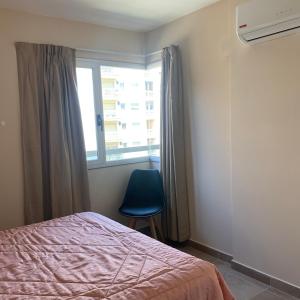 1 dormitorio con 1 cama y ventana con silla azul en Balcarce 526 en Córdoba