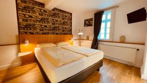 1 dormitorio con cama y pared de ladrillo en Salischer Hof, en Schifferstadt