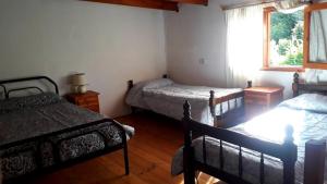 Un dormitorio con 2 camas y una ventana con en Duplex Luna en Lago Puelo