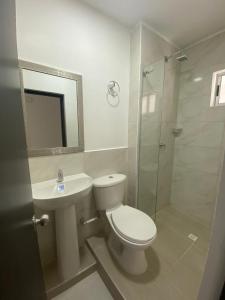 y baño con aseo, lavabo y ducha. en Apartamento Cerca al mar en Cartagena de Indias