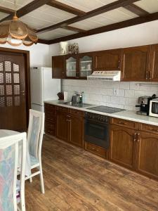 a kitchen with wooden cabinets and a stove top oven at Penzion Breuer in Jablonec nad Jizerou