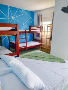 Maré Hostel Itapuã في سلفادور: غرفة نوم بسريرين بطابقين وجدار ازرق