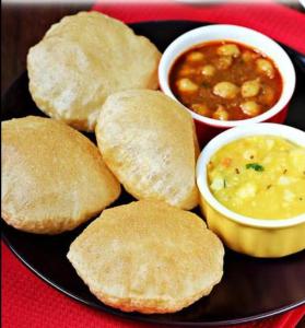 talerz jedzenia z ciastkami i miskę zupy w obiekcie Riru girlstay w mieście Patna