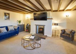 sala de estar con sofá azul y chimenea en Host & Stay - The Coach House en Whitby
