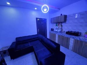 a living room with a couch and a kitchen at DINERO JADE - One Bedroom Apartment in Lagos