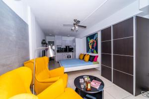 un soggiorno con divano giallo e tavolo di 1013 studio Garden City a Playa Fañabe