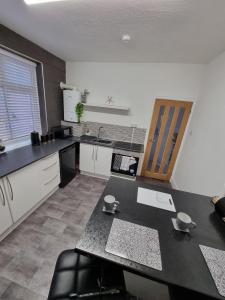 a kitchen with a table and a counter top at The View Sandbach in Sandbach