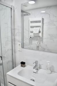 a white bathroom with a sink and a mirror at II Precioso apartamento con vistas a la Catedral in Salamanca