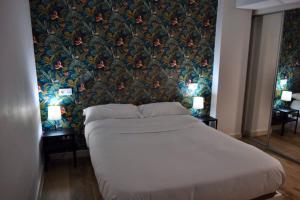 a bedroom with a large bed with a floral wallpaper at II Precioso apartamento con vistas a la Catedral in Salamanca