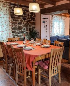 a dining room table with chairs and a table with wine bottles at Casa Rural Tozolosolobos in Otero de Bodas